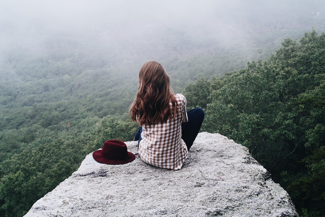 Une personne assise en méditation dans un paysage naturel